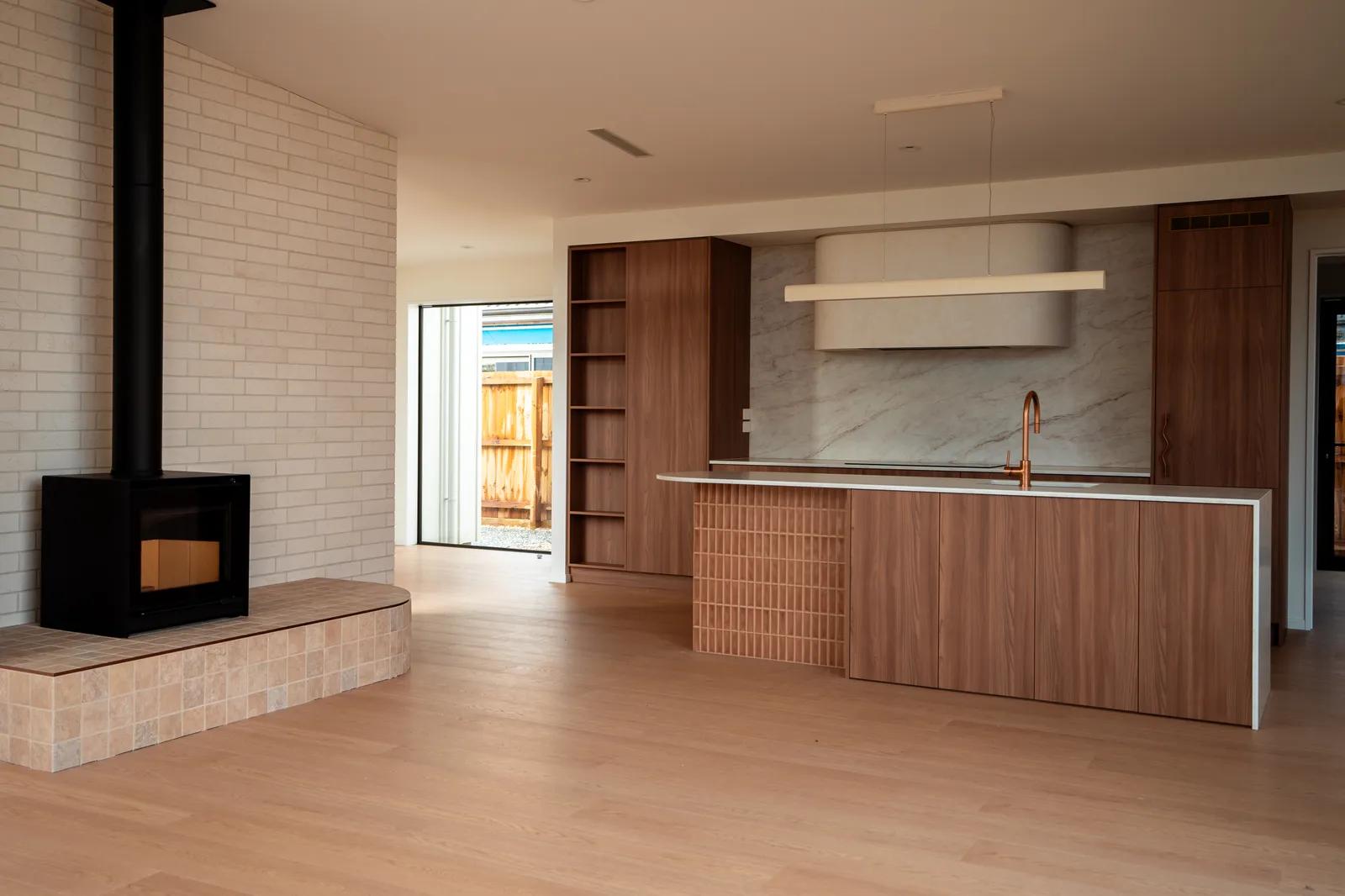 Open living with a freestanding fireplace and timber kitchen